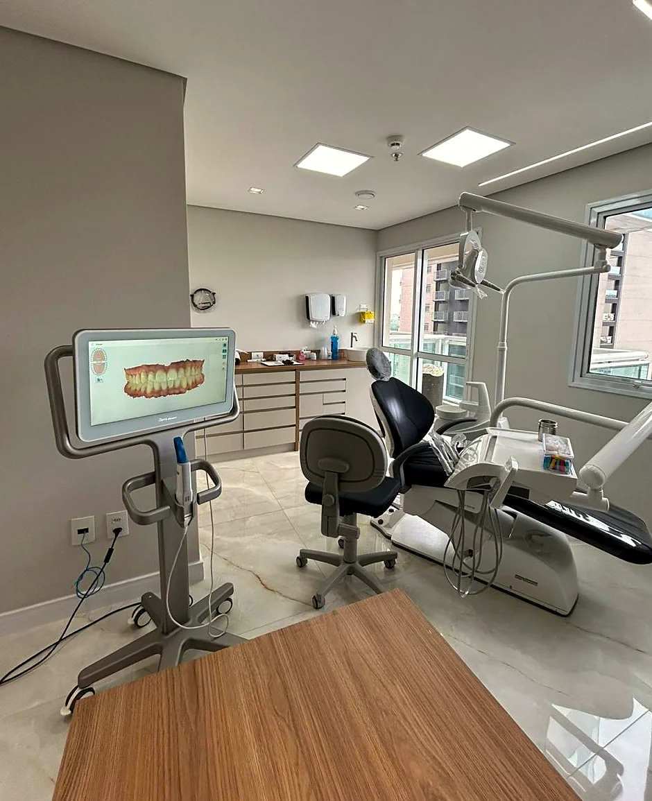 Sala clínica da Lily Asher, com cadeira odontológica e escâner intraoral iTero